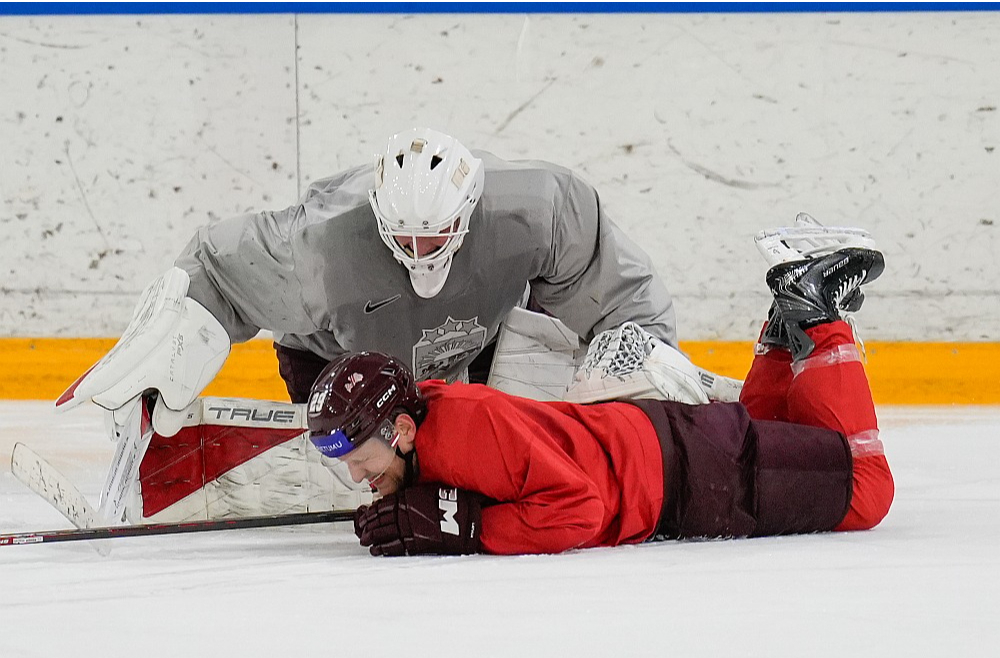 Latvijas hokeja izlases pirmajā treniņā aizsargs Ralfs Freibergs palīdz vārtsargam Bruno Brūverim. Freibergs ir pārliecinoši pieredzējušākais starp šā brīža kandidātiem, jo gatavojas savam desmitajam pasaules čempionātam.