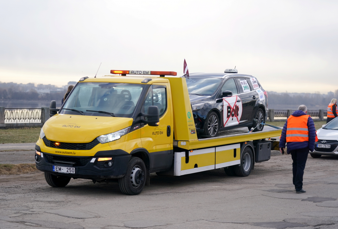 Zaķusalā notiek protesta akcija, kuru rīko Latvijā licencētie taksometru vadītāji pret "Bolt" īstenoto politiku, jo valdība nav izpildījusi nozares izvirzīto ultimātu un nav veikusi reālus soļus platformas monopola ierobežošanai.