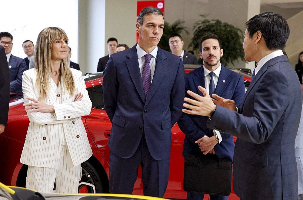 Ziņa par tiesvedības draudiem Spānijas premjeru Pedro Sančesu (vidū) un viņa dzīvesbiedri Begonju Gomesu (pa kreisi) šonedēļ sasniegusi oficiālās vizītes laikā Ķīnā.