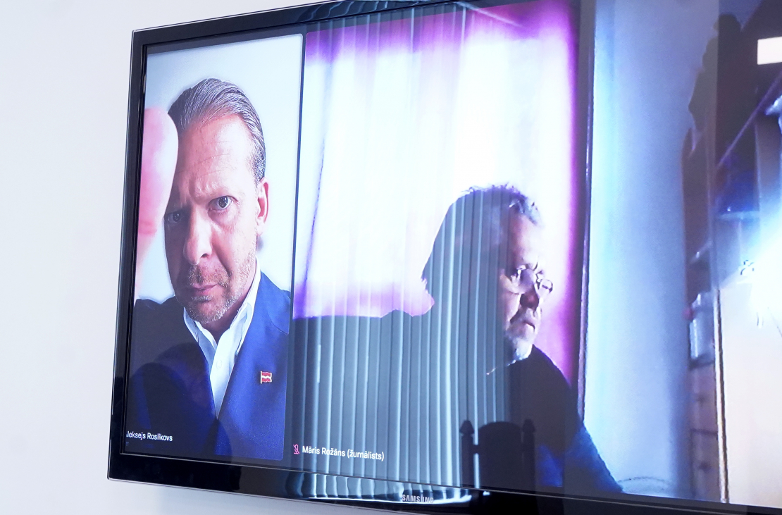 Aleksejs Rosļikovs (ekrānā no kreisās) tiesas sēdes laikā Rīgas pilsētas tiesā.