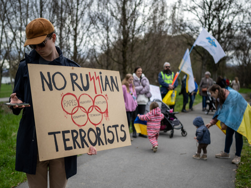Šveices pilsētā Lozannā pie Starptautiskās Olimpiskās komitejas mītnes Ukrainas atbalstītāji protestē pret Krievijas sportistu līdzdalību starptautiskās sacensībās. Plakāts vēsta “Nē krievu
teroristiem”.