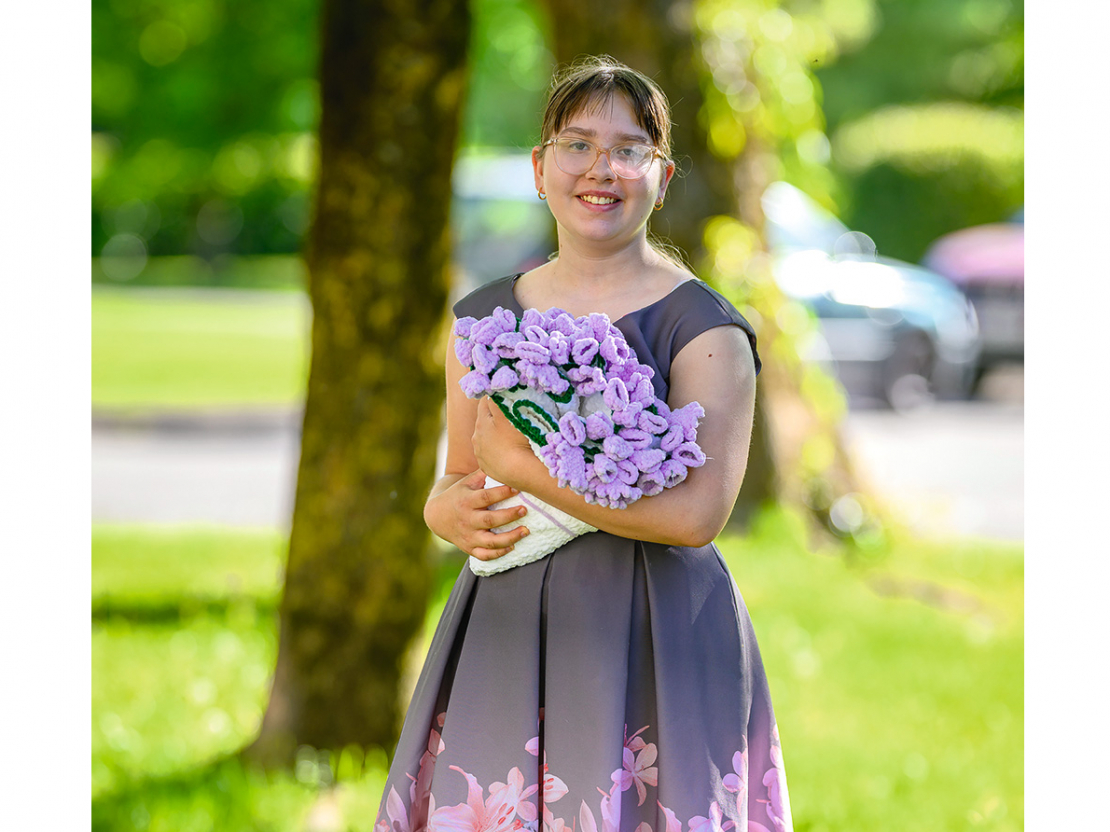 Jaunā rokdarbniece Paula Šupiņa ar savu tamborētu ziedu pušķi.