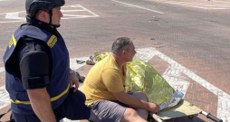 Vīrietis pie sievas līķa pēc raķešu uzbrukuma Čerņihivas centrā.