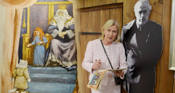 Mākslinieka meita Ilze Zvagūze-Parsons pie tēva foto un mākslinieka ilustrācijas K. Skalbes pasakai “Kaķīša dzirnavām”. Mākslinieka meita Ilze Zvagūze-Parsons pie tēva foto un mākslinieka ilustrācijas K. Skalbes pasakai “Kaķīša dzirnavām”.