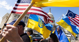 Ukrainas atbalstītāji ar karogiem pie Kapitolija ēkas priecājas par ASV Kongresa Pārstāvju palātas lēmumu.