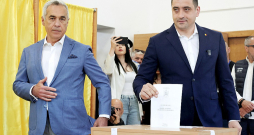 Rumānijas prezidenta amata kandidāts Džordže Simions (no labās) svētdien vēlēšanu iecirknī ieradās kopā ar pērnā gada anulēto vēlēšanu pirmās kārtas uzvarētāju Kelinu Džordžesku.
