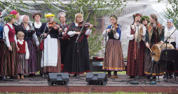 Ezermalā uzstājas folkloras kopas. Attēlā – publiku uz dančiem mudina "Skandinieki". Ezermalā uzstājas folkloras kopas. Attēlā – publiku uz dančiem mudina "Skandinieki".