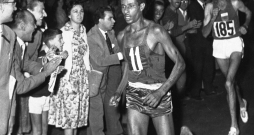 Baskājainais Abebe Bikila Romas olimpiskajā maratonā priekšā marokānim Rhadi ben Abdesalamam. Etiopietis kļuva par pirmo un vienīgo skrējēju moderno olimpisko spēļu vēsturē, kurš maratonā uzvarējis, skrienot bez apaviem.