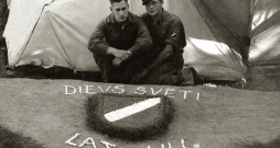 Internētie latviešu leģionāri pie pašdarināta rotājuma – latviešu leģiona vairodziņa. Ēkšes – Rennesletes nometne, 1945. gada
vasara.