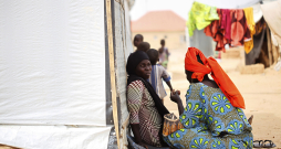 Sievietes sēž pie pagaidu telts iekšzemē pārvietoto personu (IDP) nometnē Maiduguri pilsētā Nigērijas ziemeļaustrumos, 2021. gada 19. martā. Vairāk nekā desmit gadus ilgajā "Boko Haram" krīzē Nigērijas ziemeļaustrumos īpaši cietušas sievietes un bērni, kuri kļuvuši par nolaupīšanu, piespiedu pievēršanas islāmam, fiziskas un psiholoģiskas vardarbības, piespiedu darba un piespiedu laulību upuriem. Lai gan "Boko Haram" vardarbība pret sievietēm un bērniem jau kopš grupējuma darbības sākuma ir pievērsusi starptautisku uzmanību, aizvien liels izaicinājums ir nodrošināt iekšzemē pārvietotajām personām aizsardzību un atbalstu ikdienas vajadzībām, ar ko saskaras daudzas palīdzības organizācijas.