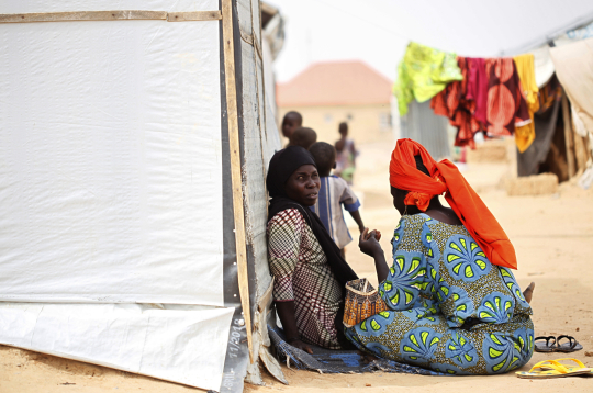 Sievietes sēž pie pagaidu telts iekšzemē pārvietoto personu (IDP) nometnē Maiduguri pilsētā Nigērijas ziemeļaustrumos, 2021. gada 19. martā. Vairāk nekā desmit gadus ilgajā "Boko Haram" krīzē Nigērijas ziemeļaustrumos īpaši cietušas sievietes un bērni, kuri kļuvuši par nolaupīšanu, piespiedu pievēršanas islāmam, fiziskas un psiholoģiskas vardarbības, piespiedu darba un piespiedu laulību upuriem. Lai gan "Boko Haram" vardarbība pret sievietēm un bērniem jau kopš grupējuma darbības sākuma ir pievērsusi starptautisku uzmanību, aizvien liels izaicinājums ir nodrošināt iekšzemē pārvietotajām personām aizsardzību un atbalstu ikdienas vajadzībām, ar ko saskaras daudzas palīdzības organizācijas.