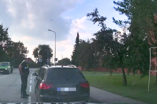 Pašvaldības policists runā ar noķerto dzērājšoferi. Pašvaldības policists runā ar noķerto dzērājšoferi.