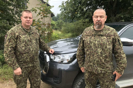 Pulkvežleitnants Kaspars Skudrovs (no kreisās) un kapteinis Ralfs Vēveris pie vienas no atsavinātajām ēkām poligonā "Sēlija".