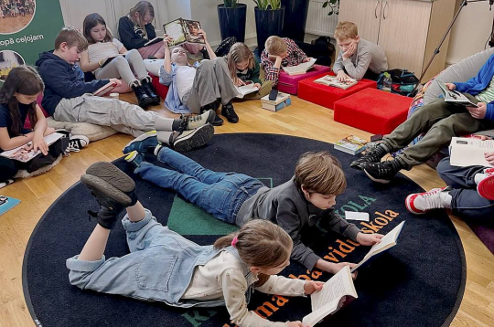 Tālmācības vidusskolas "Rīgas Komercskola" 1.-4.klašu audzēkņi šā gada aprīlī piedalās grāmatu lasīšanas pasākumā "Lasītprieks, sēžot uz lasāmspilvena", kur katram bija iespēja pārējos skolas biedrus un skolotājas iepazīstināt ar savu iecienītāko grāmatu.