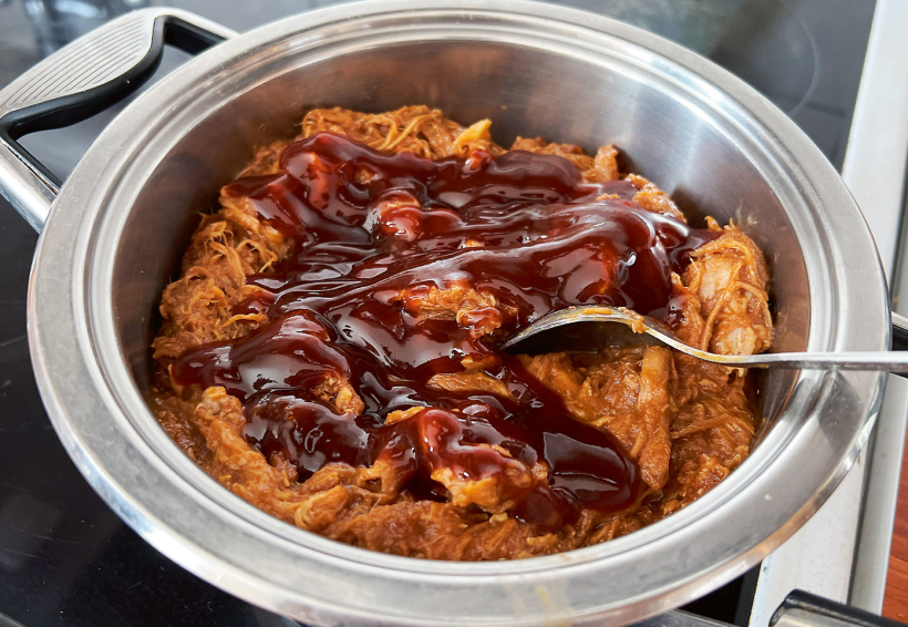 Plucināto cūkgaļu sajauc ar BBQ mērci. Plucināto cūkgaļu sajauc ar BBQ mērci.