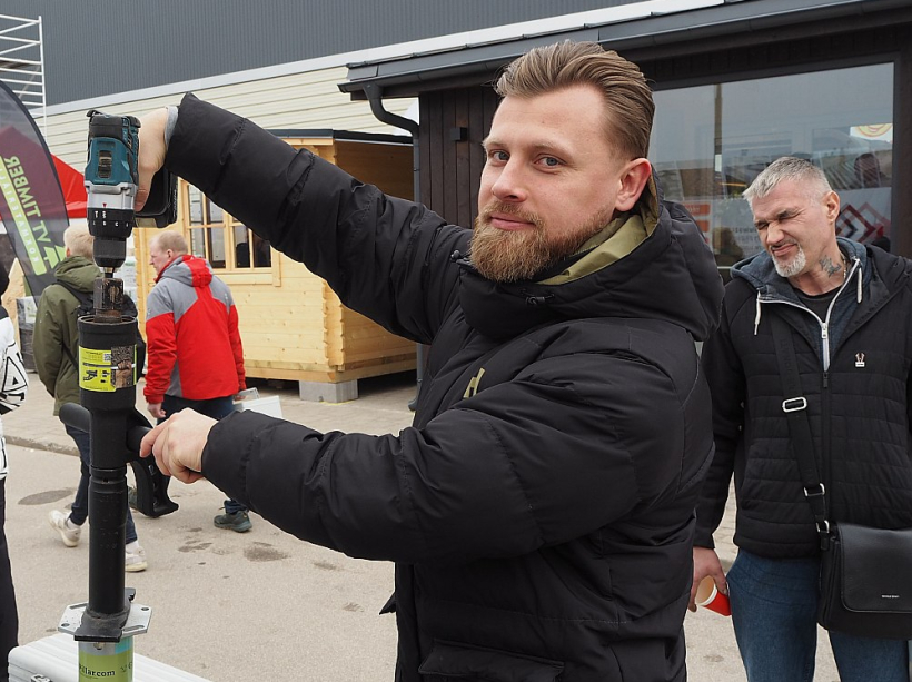 Miks Ķēdis, "Ponton.lv" tirdzniecības pārstāvis, demonstrē rokas reduktoru skrūvpāļu iestrādei zemē.