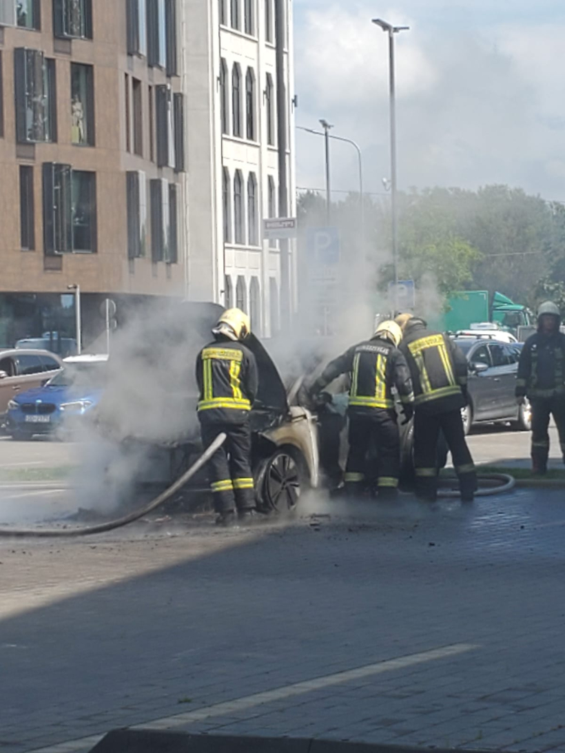 Rīgā, Mūkusalas ielas biroju stāvvietā ugunsdzēsēji dzēš elektrisko automobili.
