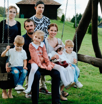 Ģimenes foto: šūpolēs sēž (no kreisās) Teodors, tētis Renārs ar meitu Tīnu klēpī, Zanda ar jaunāko meitiņu Gerdu, blakus Tālavs, aiz šūpolēm stāv vecākie bērni Viktorija un Tomass.