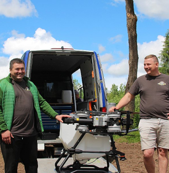 Jaunais saimnieks Elvis Bartkevičs (no labās) un saimniecības darbinieks Andrijs optimistiski lūkojas uz nākotnes tehnoloģiju – agrodronu – izmantošanu "Riekstiņu Amatnieku" tīrumos.