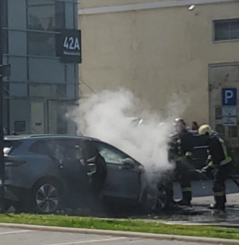 Rīgā, Mūkusalas ielas biroju stāvvietā ugunsdzēsēji dzēš elektrisko automobili.