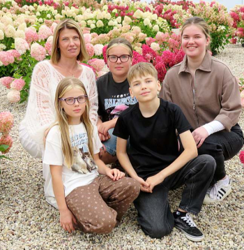 Ošiņu ģimene Neretas hortenziju dārzā. Priekšā (no kreisās) Paula un Artūrs, aizmugurē Indra, Egita, Alise. Vecākie dēli Markuss un Valters jau prom no skolas sola. Indra Ošiņa stāsta, ka dažkārt apkārtējie cilvēki slavējot, ka bērni vienmēr saposti un smaidīgi: "Un tad man ir milzīgs gandarījums, grūtības un sliktais piemirstas."