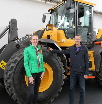 Gusts Lūsis un Laura Lūse pie Latvijā un Igaunijā vienīgā elektriskā "Volvo L25 Electric" riteņu iekrāvēja, iepazīstinot ar "Rāmavas" izstādi un izrādot plašo tehnikas klāstu, kas tiks izmēģināta arī praktiski astoņos demonstrējumu laukumos.
