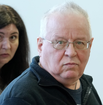 Karā pret Ukrainu iesastīto Krievijas militārpersonu atbalstīšanā apsūdzētais Sergejs Ņikitins (priekšplānā) un tiesas darbiniece Rīgas pilsētas tiesā, kas izskata pret Ņikitinu ierosināto krimināllietu.