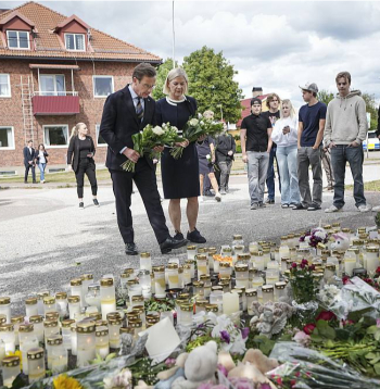 Zviedrijas premjers Ulfs Kristersons un parlamentārās opozīcijas līdere, sociāldemokrātu partijas priekšsēdētāja Magdalena Andersone improvizētajā memoriālā pie Fāgeštas vidusskolas.