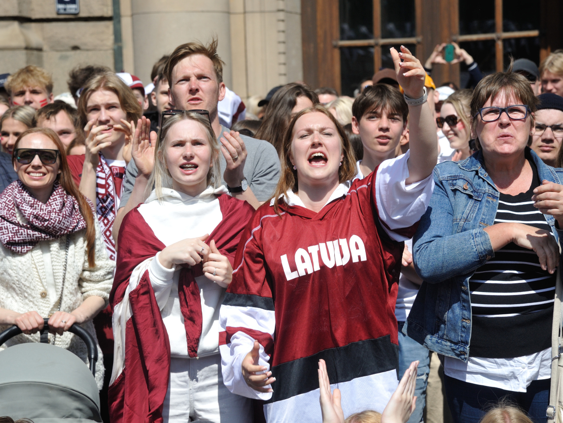 Latvijas hokeja izlases līdzjutēji vēro spēli Doma laukumā.