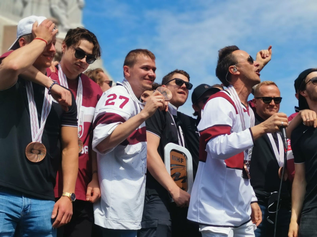 Cilvēki pie Brīvības pieminekļa sagaida hokeja varoņus.