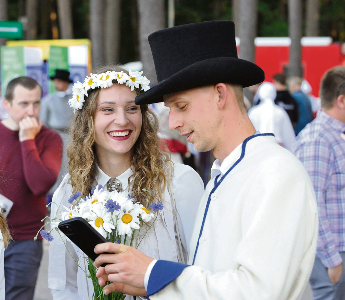 Svētku dalībnieki īsā sarunā.