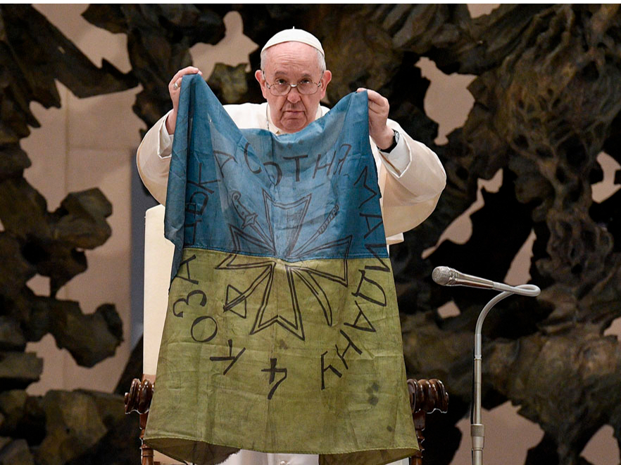 Pāvests Francisks ar Ukrainas karogu, kas viņam atsūtīts no Ukrainas pilsētas Bučas. Pirms diviem gadiem tur notika nežēlīgs slaktiņš, kad Krievijas okupantu spēki nogalināja ukraiņu civiliedzīvotājus. Pāvests ir aicinājis pārtraukt karu Ukrainā, taču daži viņa izteikumi izsaukuši neizpratni, jo radīja iespaidu, ka Francisks aicina ukraiņus padoties Krievijas okupācijas varai.