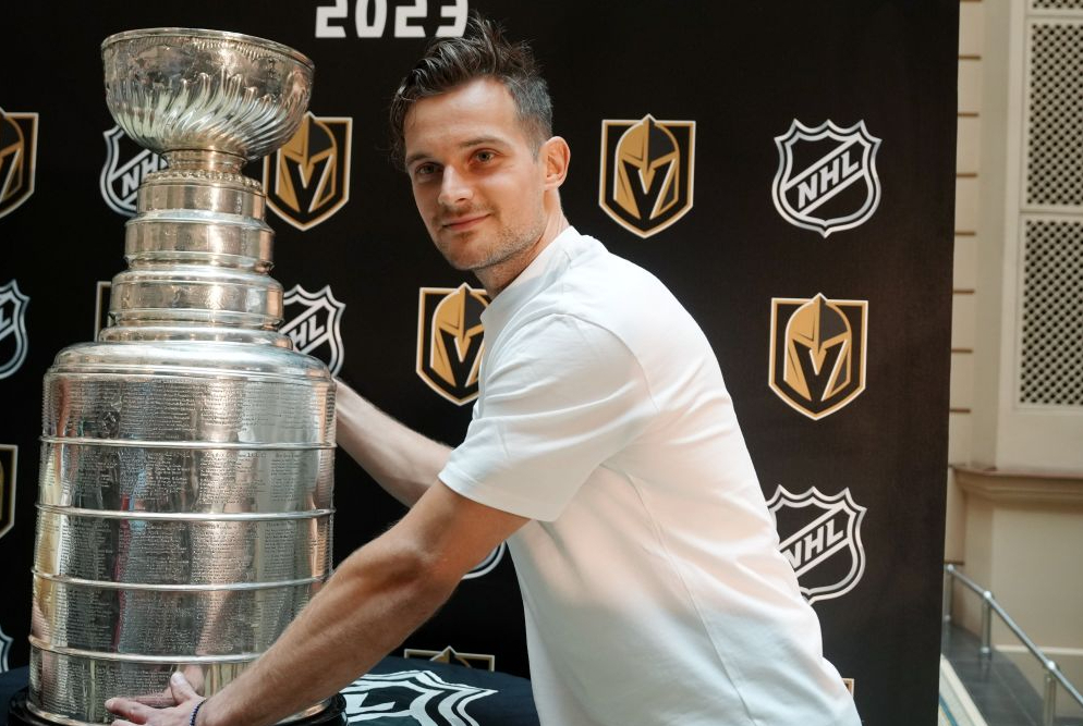 Latvijas hokejists Teodors Bļugers 2023. gada augustā pasākumā, kura laikā mākslas muzejā "Rīgas Biržā" bija iespēja aplūkot Nacionālās hokeja līgas Stenlija kausu.