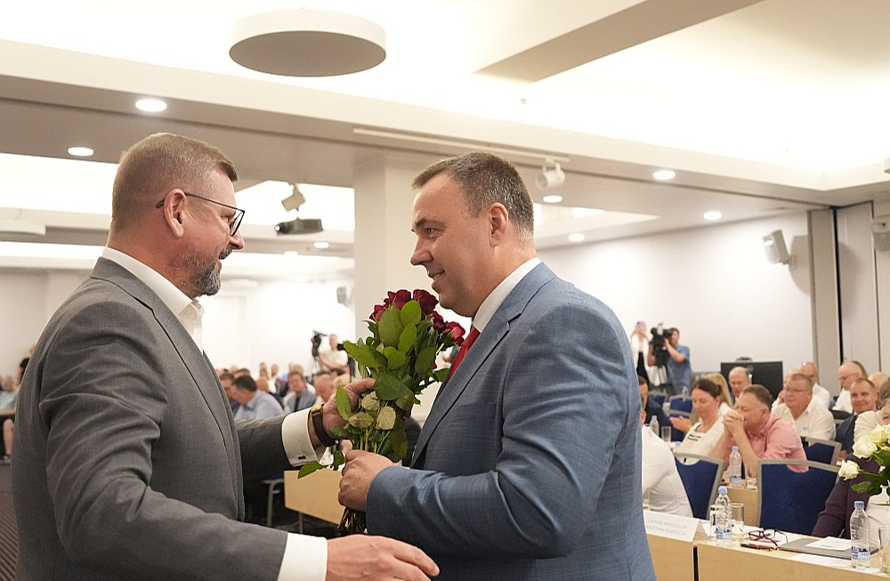 Jānis Buks (no kreisās) sveic Raimondu Lazdiņu ar uzvaru vēlēšanās.