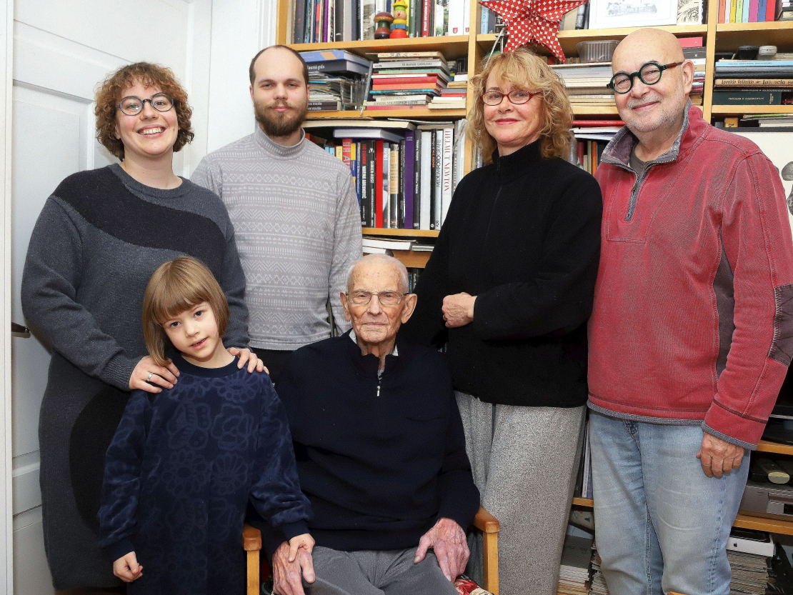 Ošu ģimene savās dzimtas mājās. Sēž Ēriks Ošs, no kreisās – Mežalu ģimene: Ērika mazmeita Emīlija ar vīru Mārtiņu un meitiņu Elizabeti, meita Ērika un viņas vīrs Juris Petraškēvičs. 2024. gada 10. decembrī.