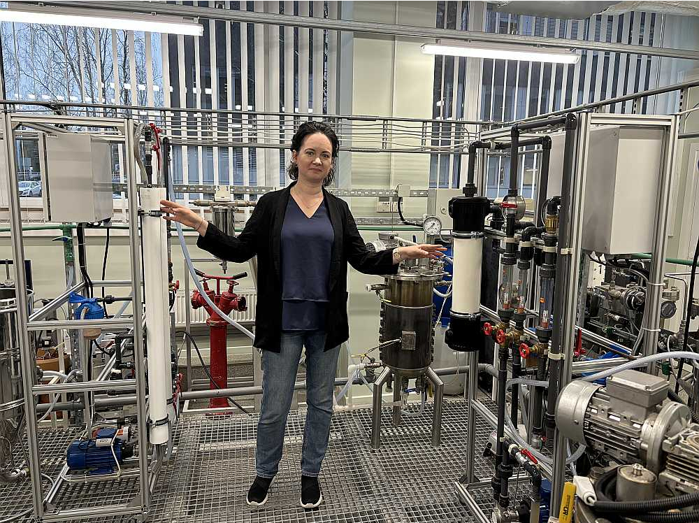 Projekta vadītāja RTU asociētā profesore Linda Mežule demonstrē projekta laikā izveidoto un patentēto daudzpakāpju membrānu sistēmu filtru, ar kuru ūdeni, cukura šķīdumu un cukuru atdala no nesašķeltajām daļiņām.