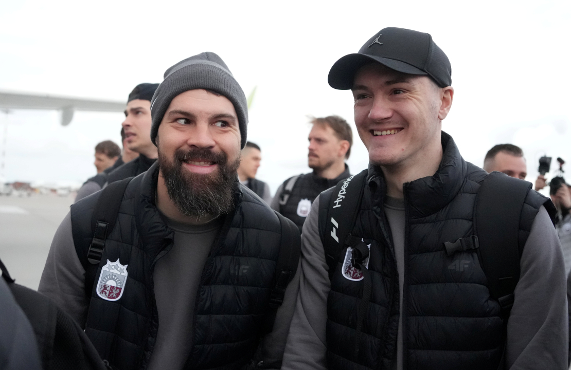 Latvijas hokeja izlases spēlētāji Kaspars Daugaviņš (no kreisās) un Kristaps Roberts Zīle Rīgas lidostā pirms došanās uz 2025. gada pasaules hokeja čempionātu Stokholmā.