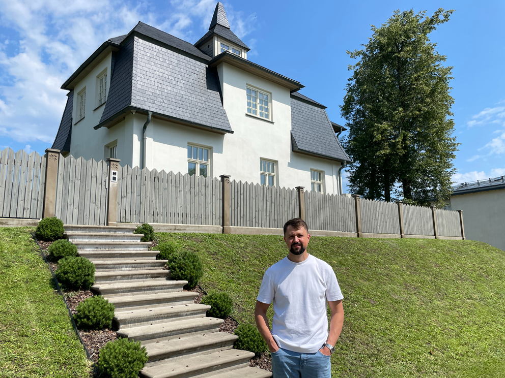 Jānis Vilciņš pie sava nama ar ieeju no Raiņa ielas.