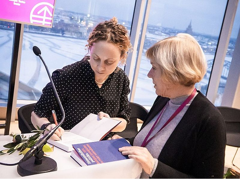 Vēsturniece Una Bergmane (no kreisās) grāmatas "Nenoteiktības politika: ASV, Baltijas jautājums un Padomju Savienības sabrukums" atvēršanā sniedz autogrāfus.