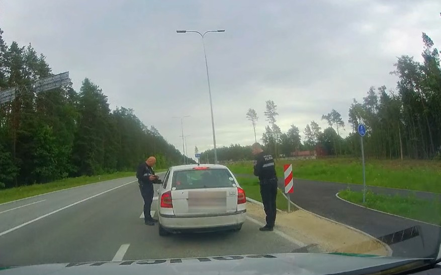 Ropažu novada pašvaldības policijas darbinieki pie apturētā auto.