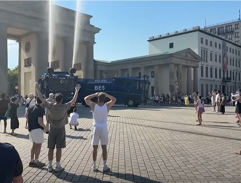 Vācijā pie Brandenburgas vārtiem cilvēki varēja veldzēties zem policijas auto "izšautajām" ūdens strūklām.