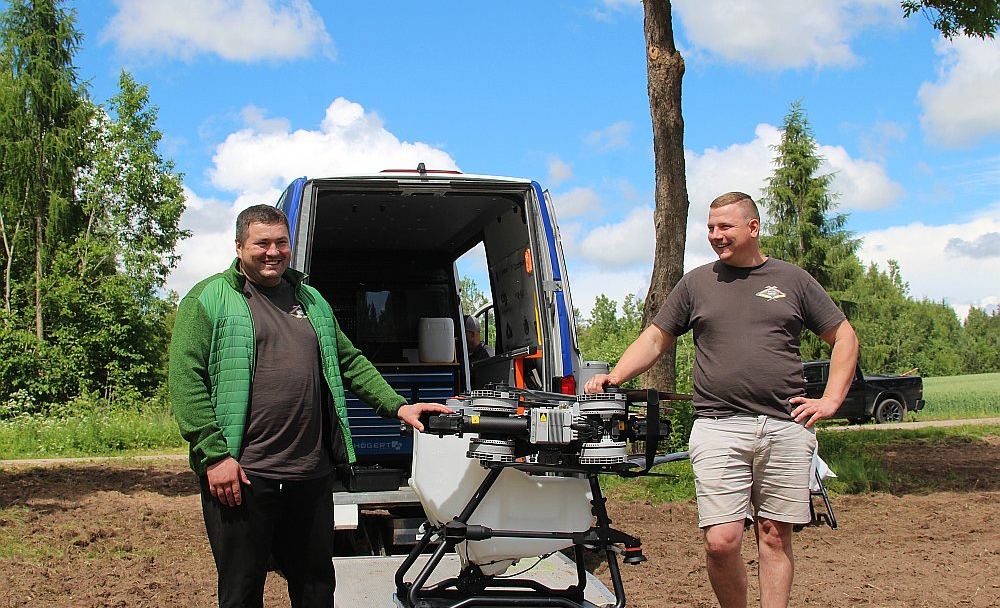 Jaunais saimnieks Elvis Bartkevičs (no labās) un saimniecības darbinieks Andrijs optimistiski lūkojas uz nākotnes tehnoloģiju – agrodronu – izmantošanu "Riekstiņu Amatnieku" tīrumos.