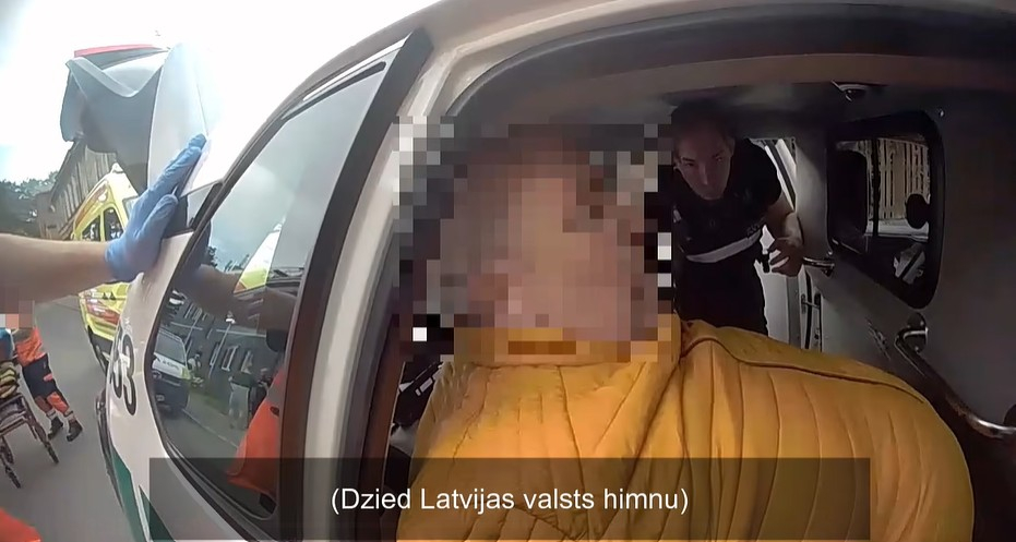 Rīgas pašvaldības policijas aizturētais vīrietis likumsargu automašīnā.