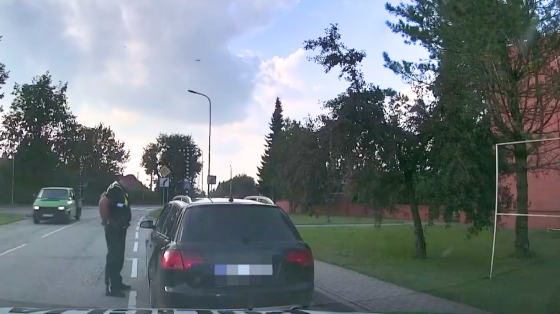 Pašvaldības policists runā ar noķerto dzērājšoferi.