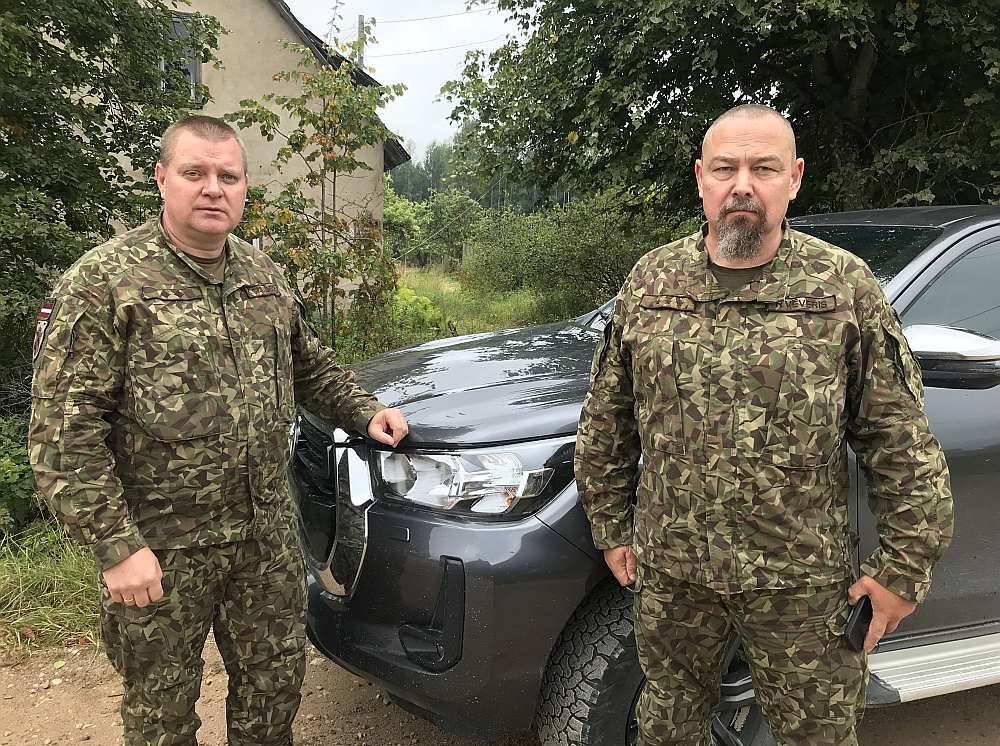 Pulkvežleitnants Kaspars Skudrovs (no kreisās) un kapteinis Ralfs Vēveris pie vienas no atsavinātajām ēkām poligonā "Sēlija".