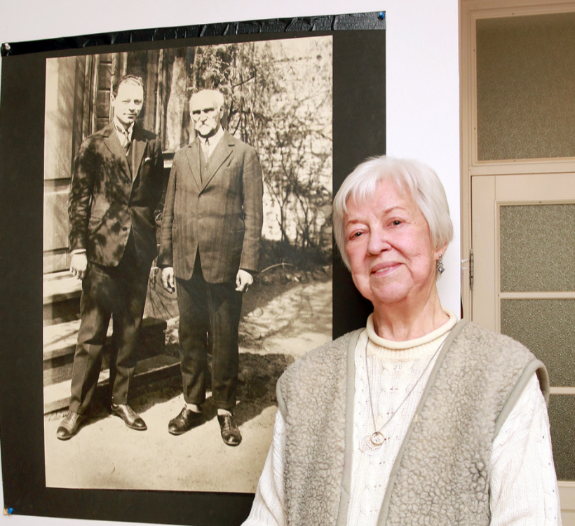 Māra Celle pie vēsturiskas fotogrāfijas, kurā redzams Rainis kopā ar viņas tēvu Jūliju Lāci. 