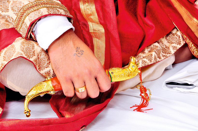 Indijas līgavainis tur kāzu nazi kirpan.