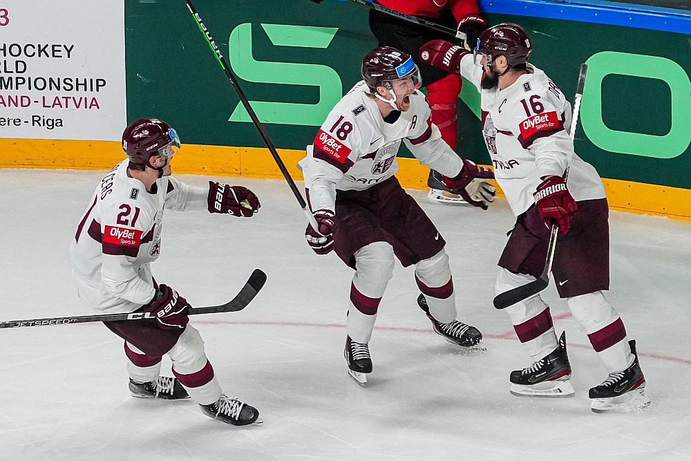 Rūdolfs Balcers (no kreisās) un Rodrigo Ābols steidz apsveikt maiņas partneri un komandas kapteini Kasparu Daugaviņu, kurš piecas minūtes pirms pamatlaika beigām ar vārtu guvumu Latvijas izlasei pavēra ceļu uz ceturtdaļfinālu.