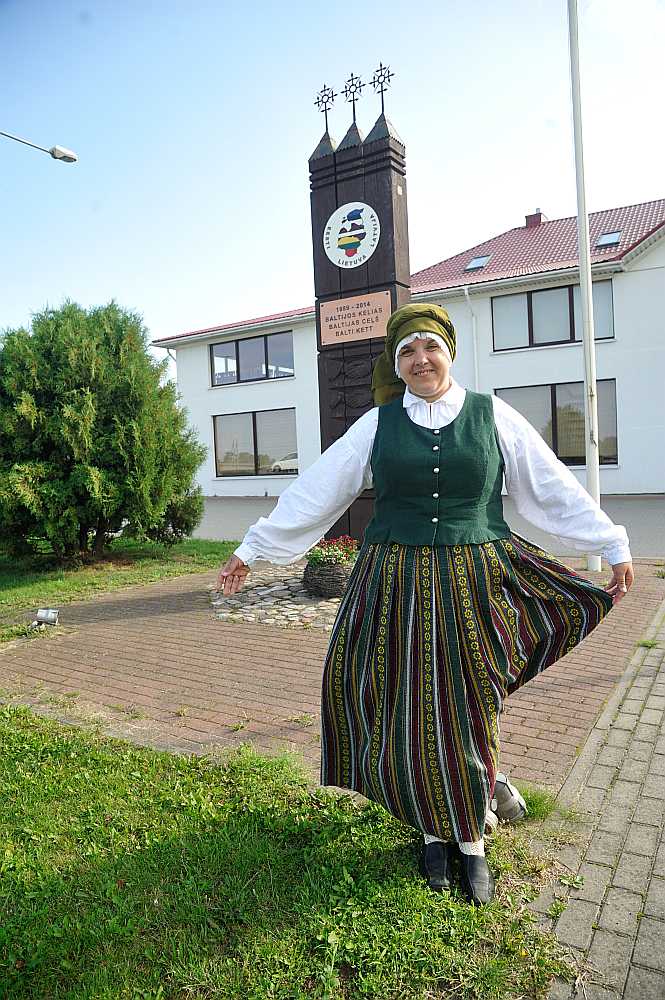 Grenctāles kultūras nama vadītāja Jurgita Červinska. Aiz viņas: piemiņas zīme 1989. gadā notikušajam Baltijas ceļam.