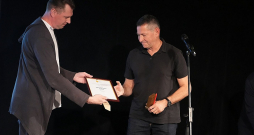 Žūrijas vadītājs Arnis Krauze (no kreisās) pasniedz balvu Atim Klimovičam.